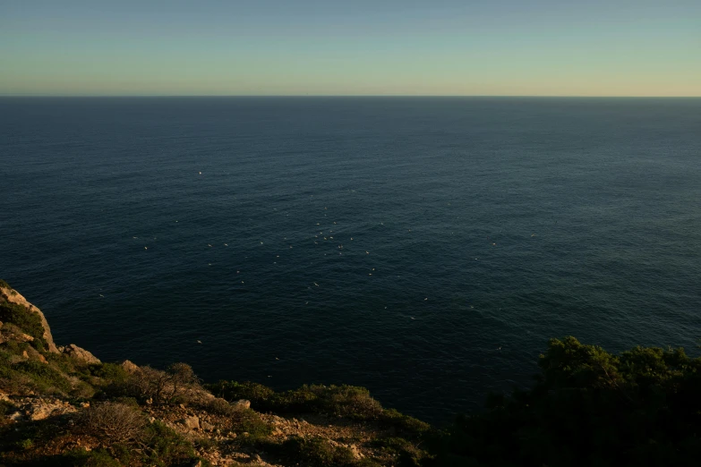 an ocean view with a very steep hill next to it