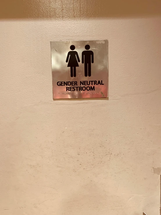 a restroom sign and toilet stall in the corner