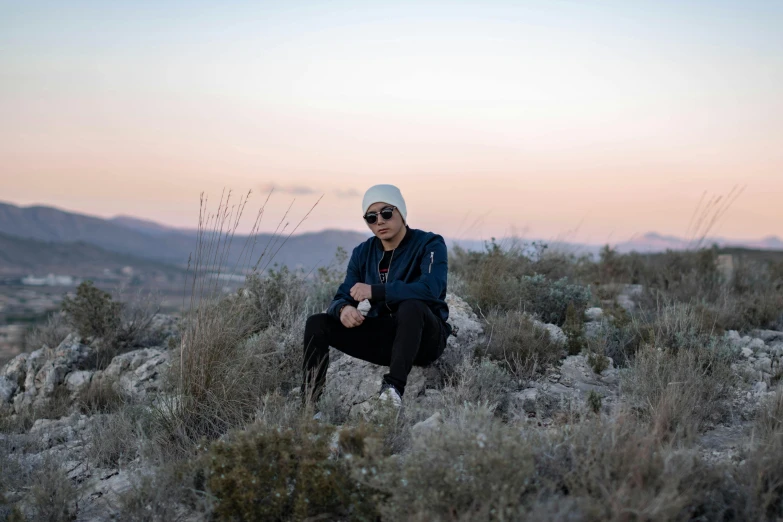 a man sitting on the edge of a field of grass