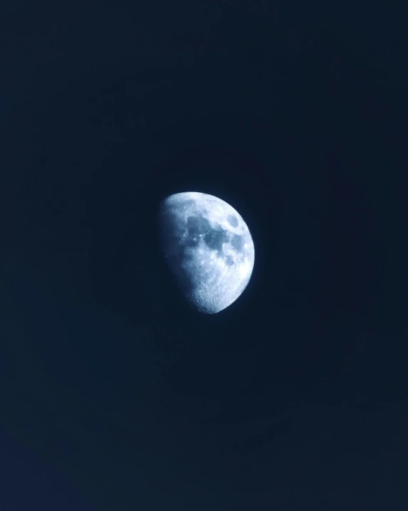 the moon in a blue night sky during the day