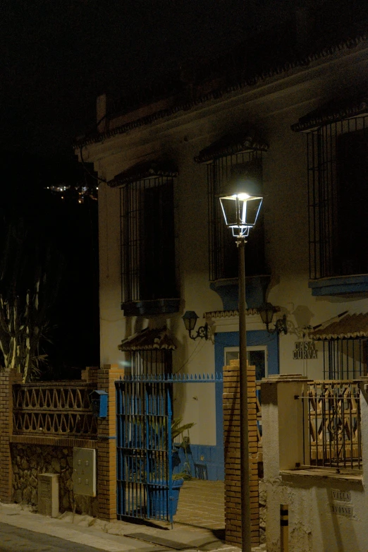 a street lamp standing outside a home at night