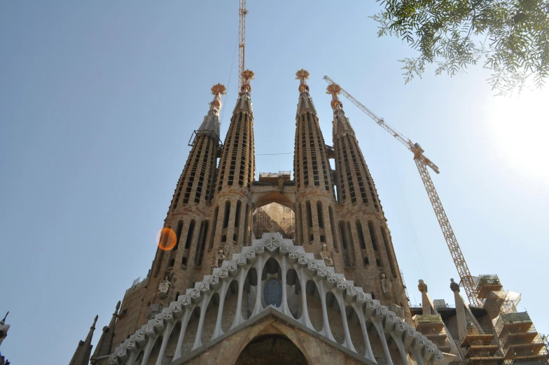 a large tall tower with several cranes around it