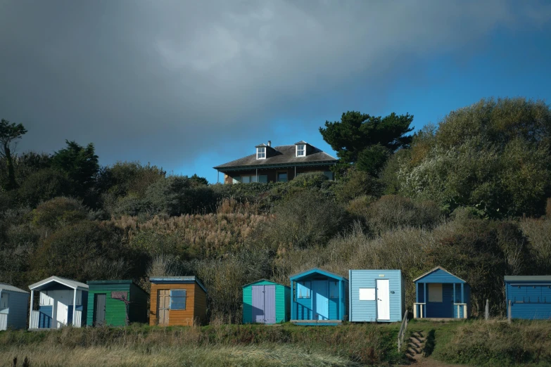 the row of beach huts sits on a hill