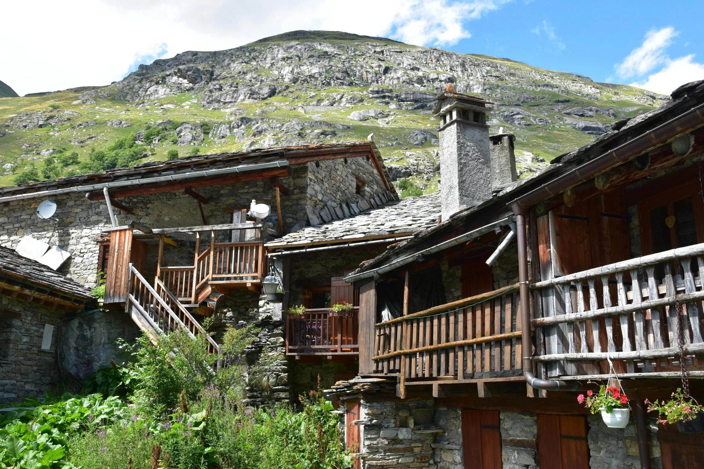 old stone building in mountainside near grassy area