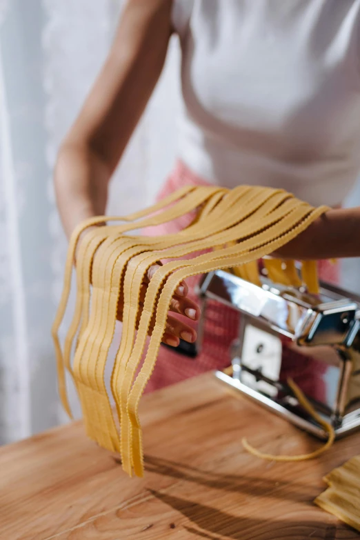 a woman holding a pair of yellow scissors while pulling it through a metal binding