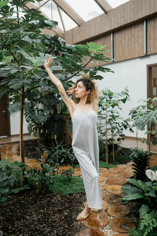 a woman poses in the middle of a garden