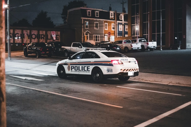 a police car on the street in front of a building