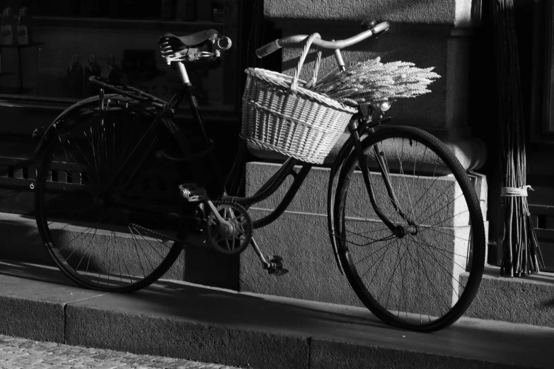 an old style bicycle parked on the sidewalk near a curb