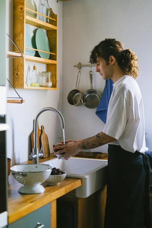 a lady preparing food and standing in a kitchen