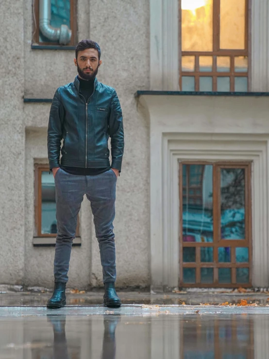 man with beard standing near grey building