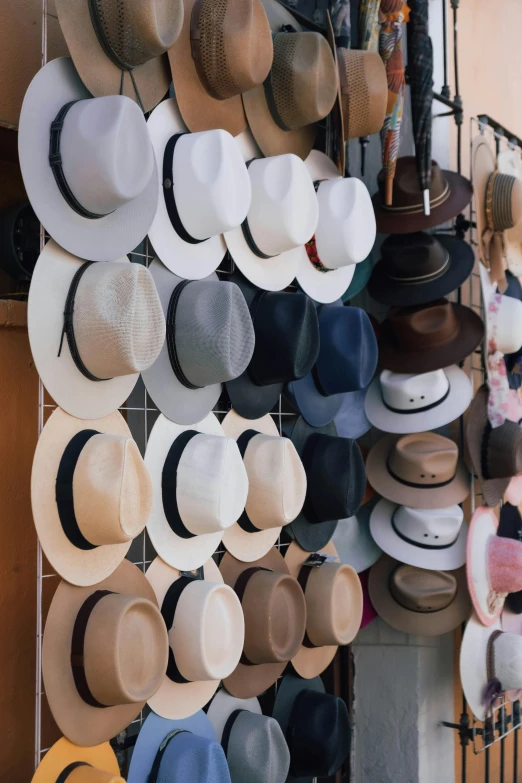 many hats hanging up on a metal rack
