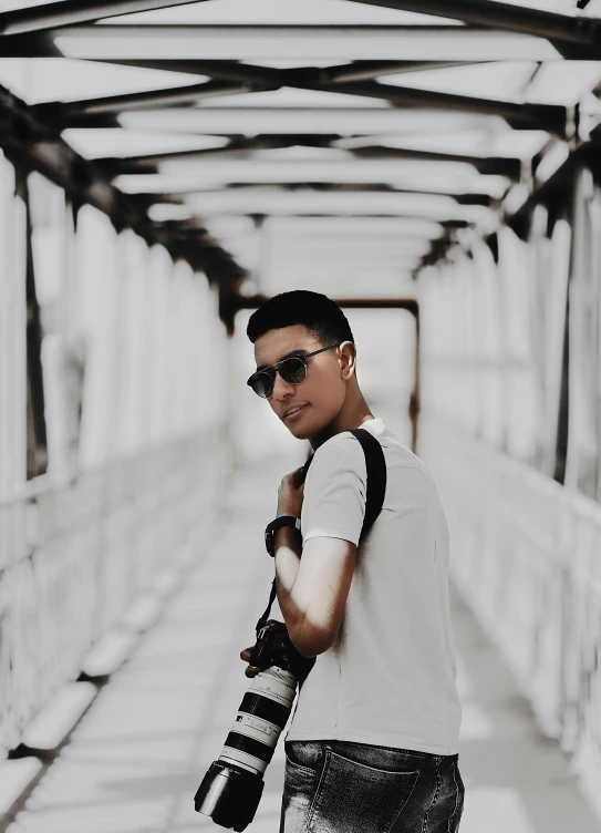 a man in sunglasses stands near an underpass