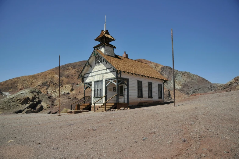 old western style building in the desert with a steeple on top