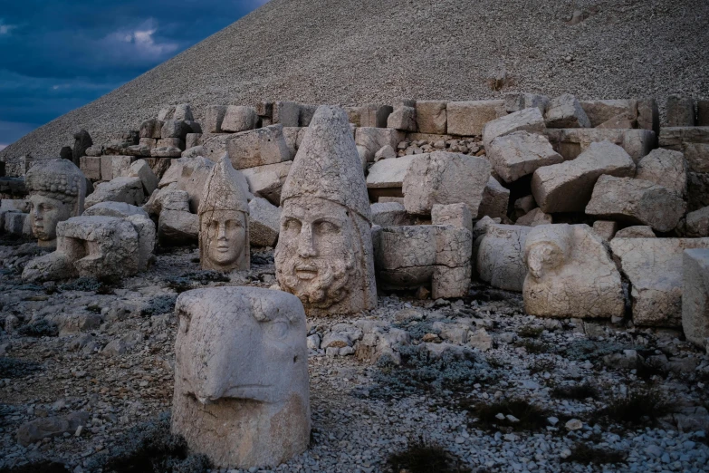 statues in front of an old pyramid in the desert