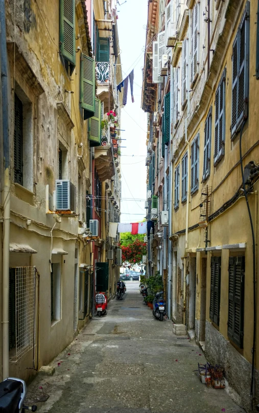 street lined with yellow buildings and blue shutters