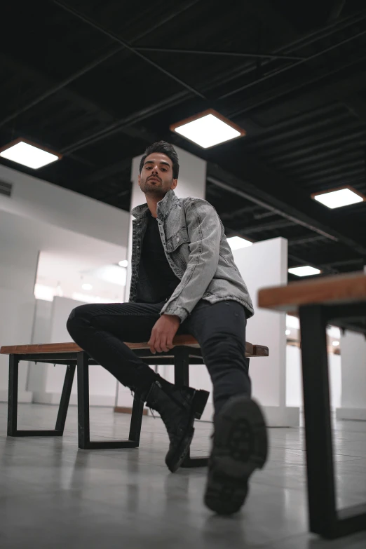 a man sitting on top of a wooden bench