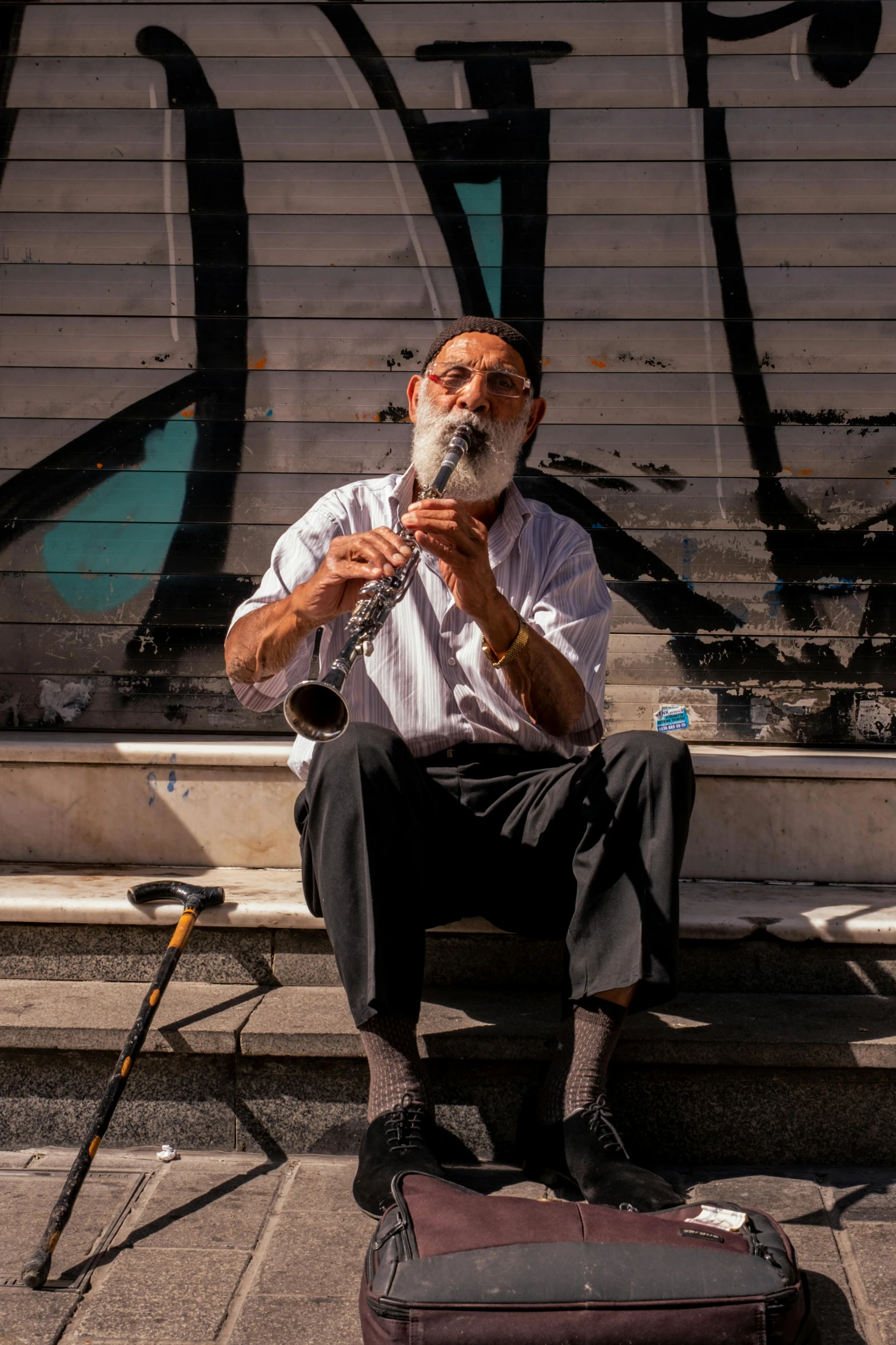 an old man sitting on the steps with a pipe in his hands