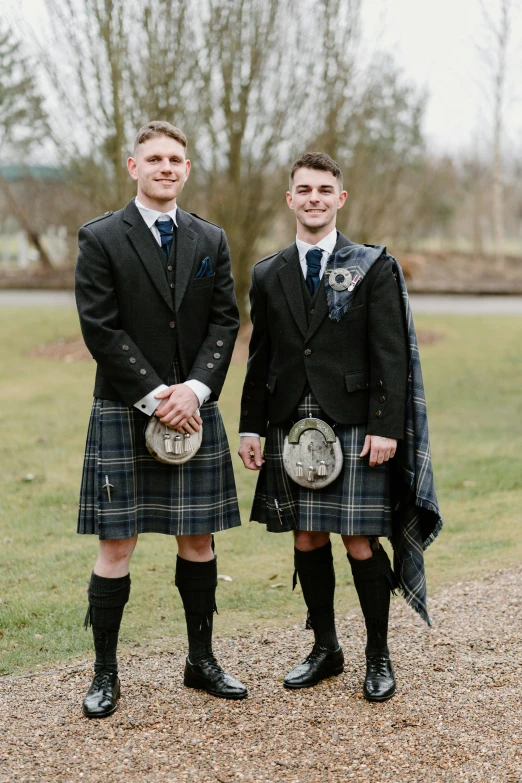 two men in kilts wearing plaid clothing and holding tarns