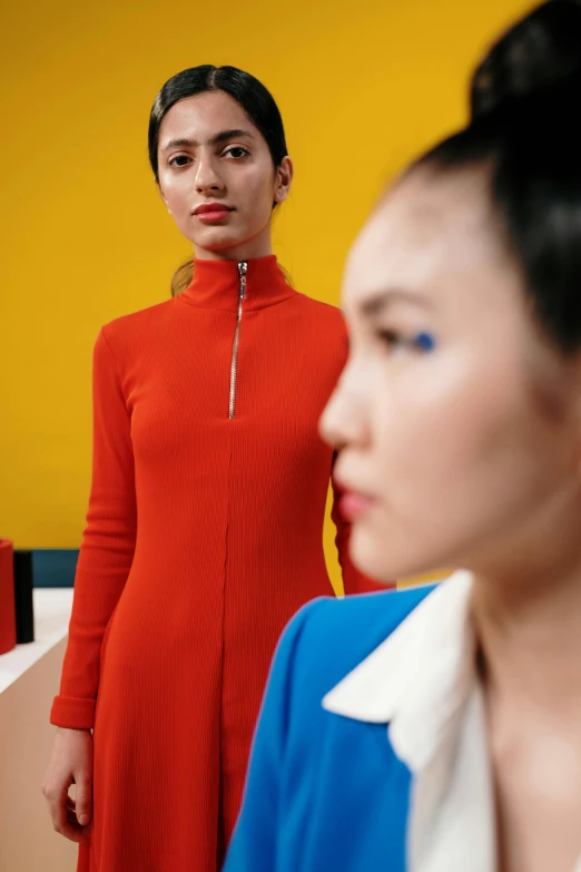 a woman in a red dress standing next to another person