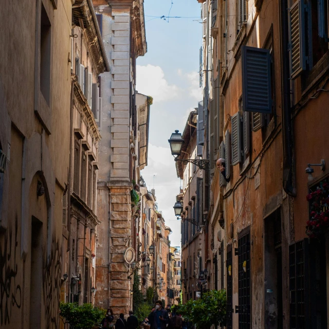 some people walk down an old cobblestone road in the city