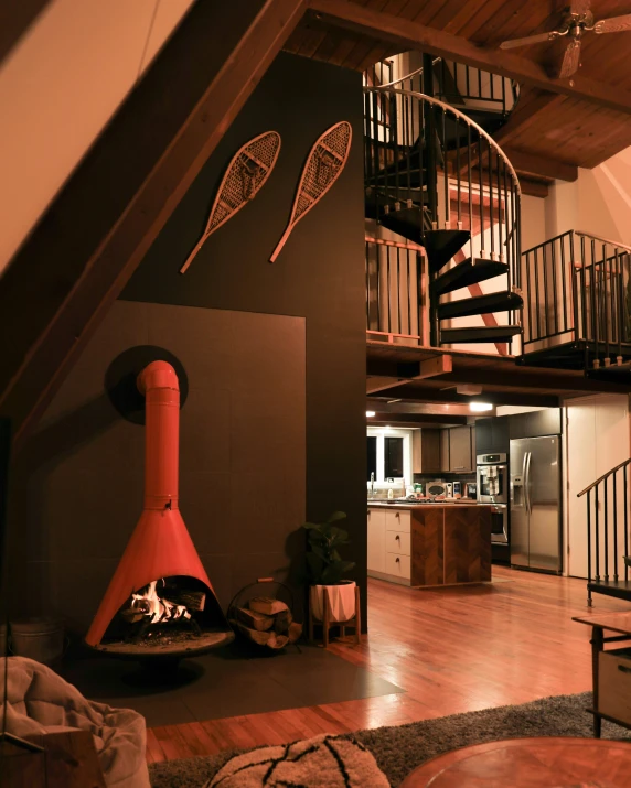 a living room with staircase, wood floors and an open fireplace