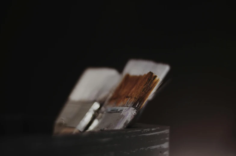 a stack of paint brushes sitting on top of a table