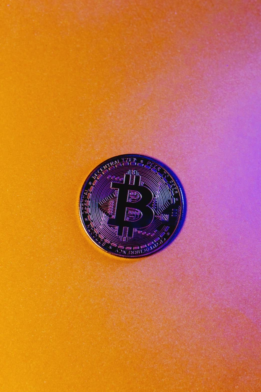 a bitcoin sits atop a yellow surface