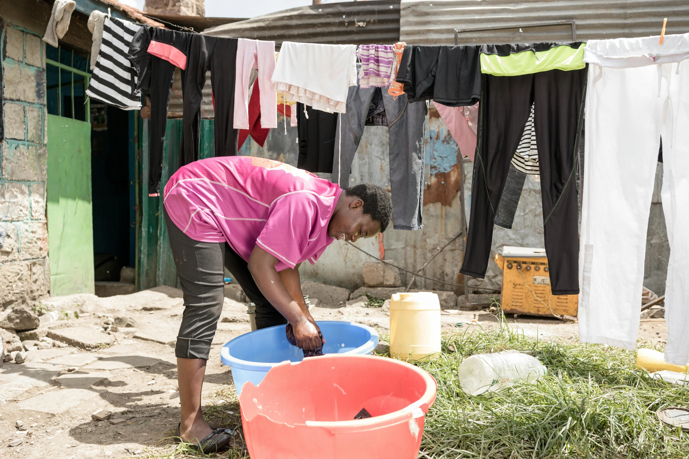 a woman standing over three buckets filled with water