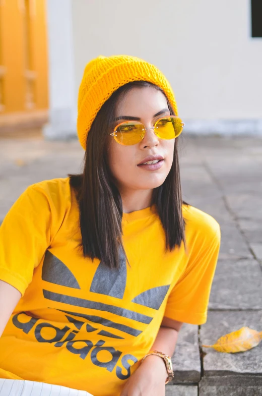 a girl wearing sunglasses and a yellow shirt