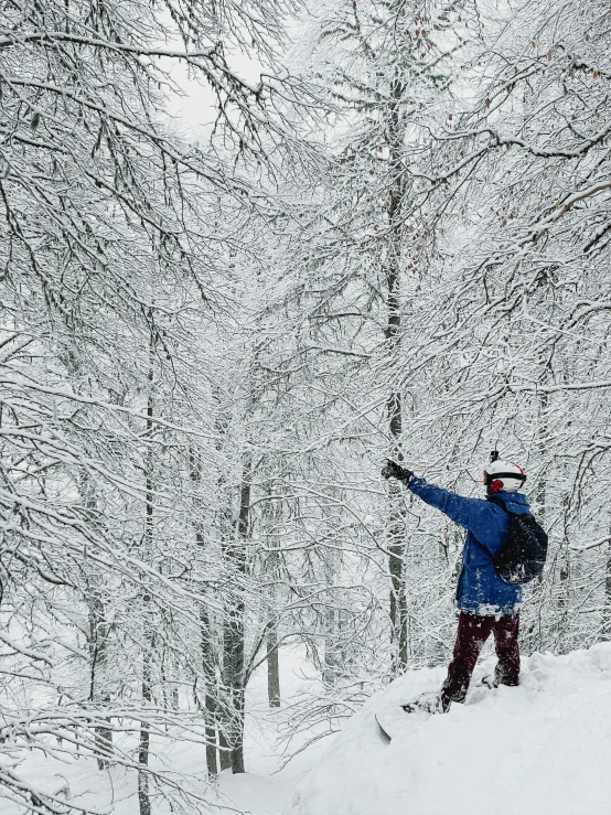 the person is in blue clothes snowboarding on the hill