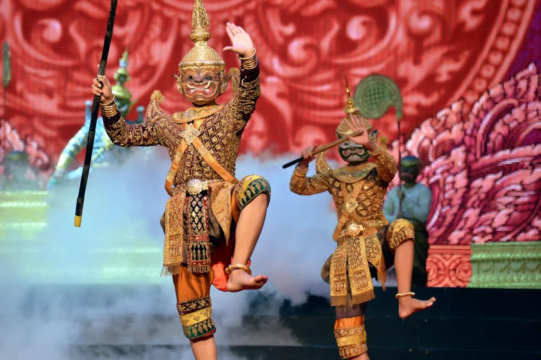 performers perform during a show with a large red backdrop