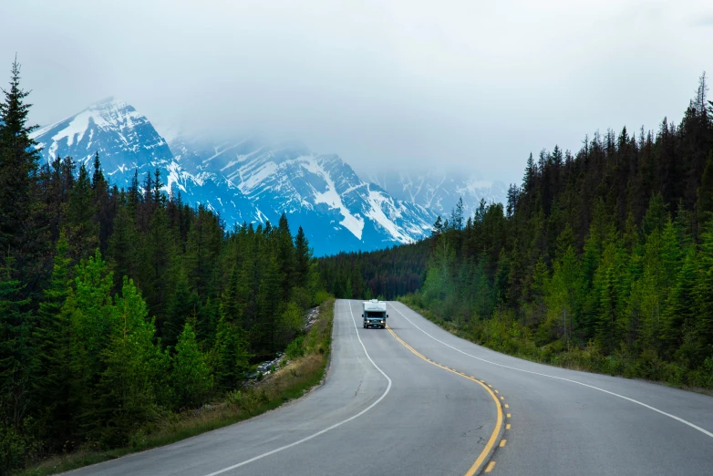 an empty road with mountains in the background