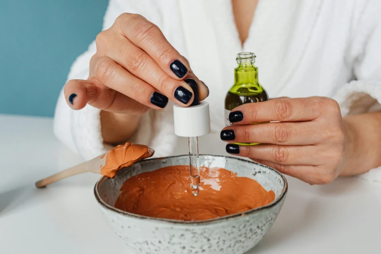 woman wearing blue nails pouring in a bowl