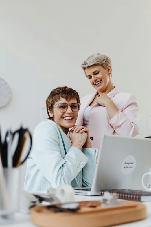 a man and a woman who are looking at a laptop