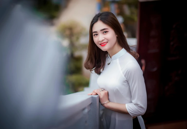 a young woman posing by a gate