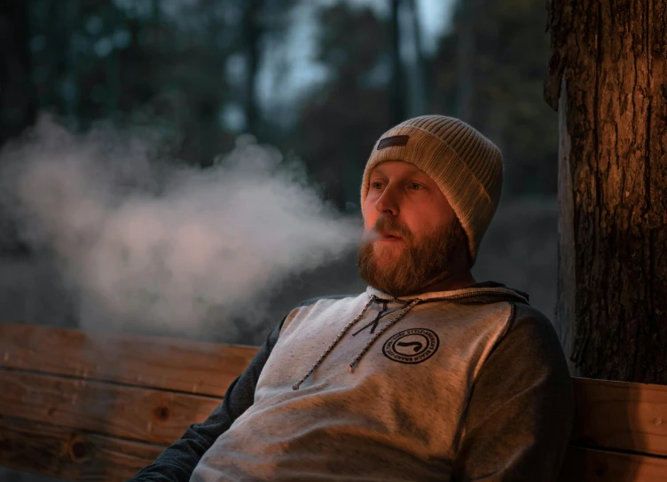 a man that is sitting down on a wooden bench