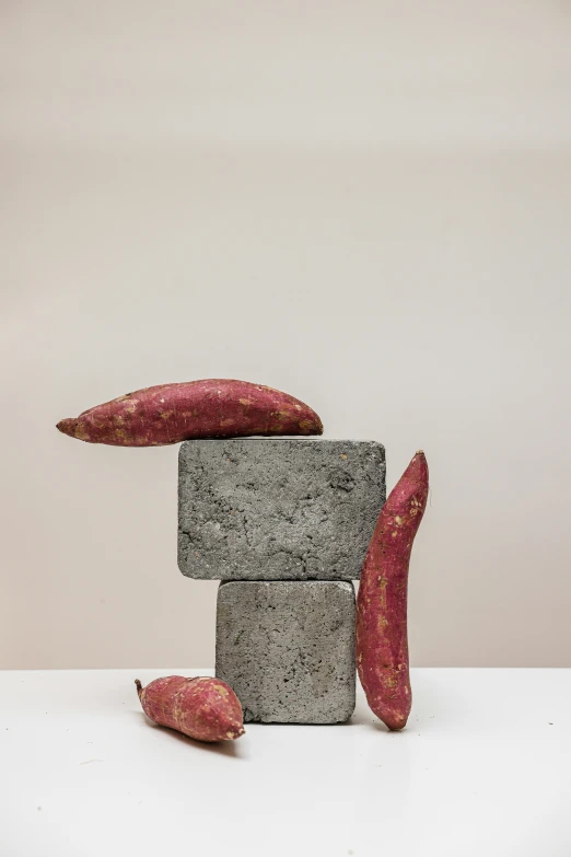 a gray stone sculpture with red pillows on top