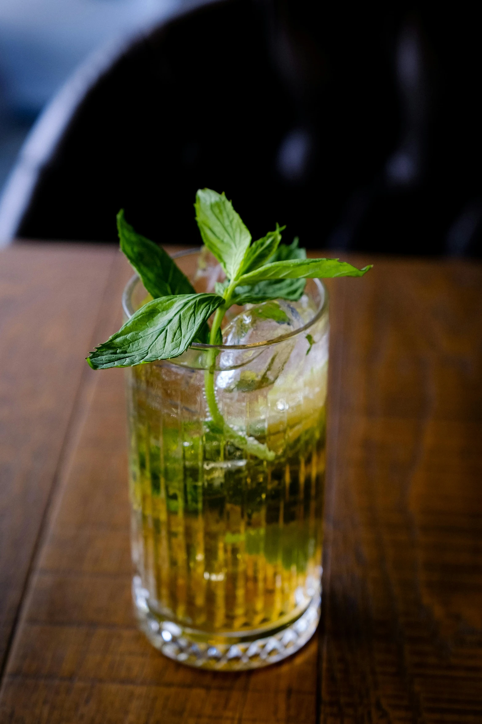 a glass of lemonade with mint on a wooden table