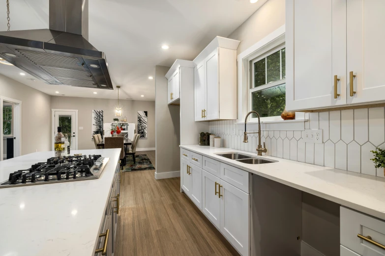 a large kitchen with white counter tops and wooden floors