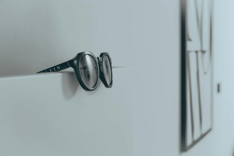 the eyewear is on the wall next to the glasses