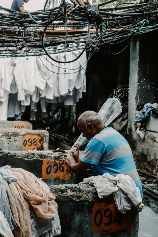 an old man sits on some cement looking at soing