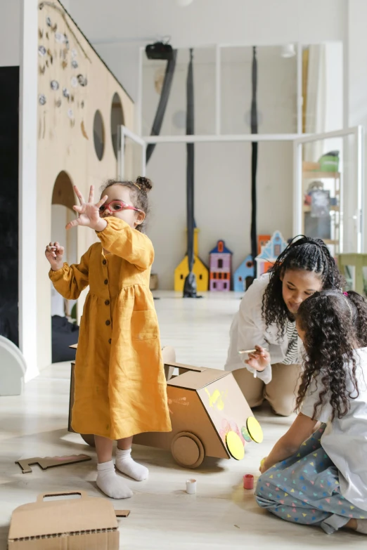 two little girls playing with toys on the floor