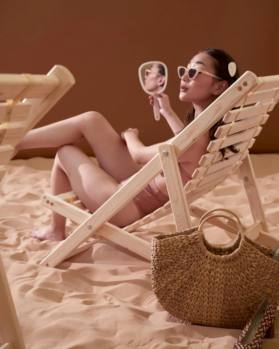 woman on beach chair with mirror and purse