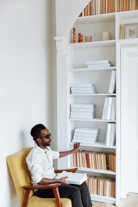 a man sitting on a chair with glasses on