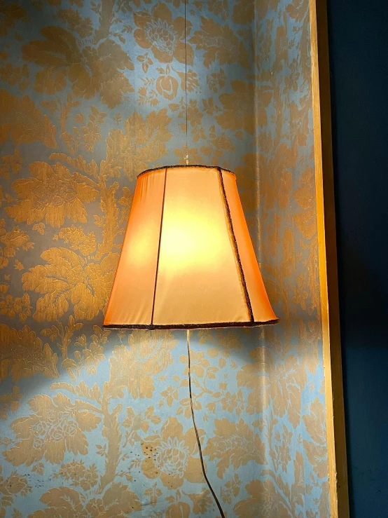 a lamp shines brightly in front of a blue wall