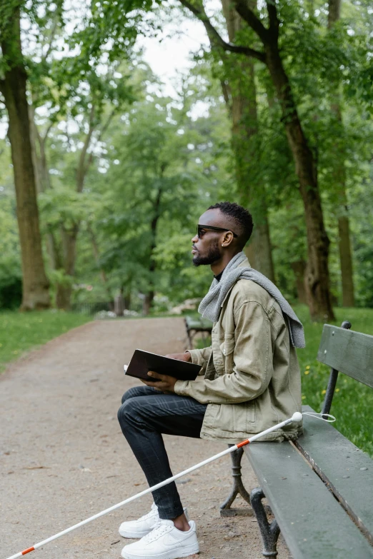 an image of man sitting alone holding a book