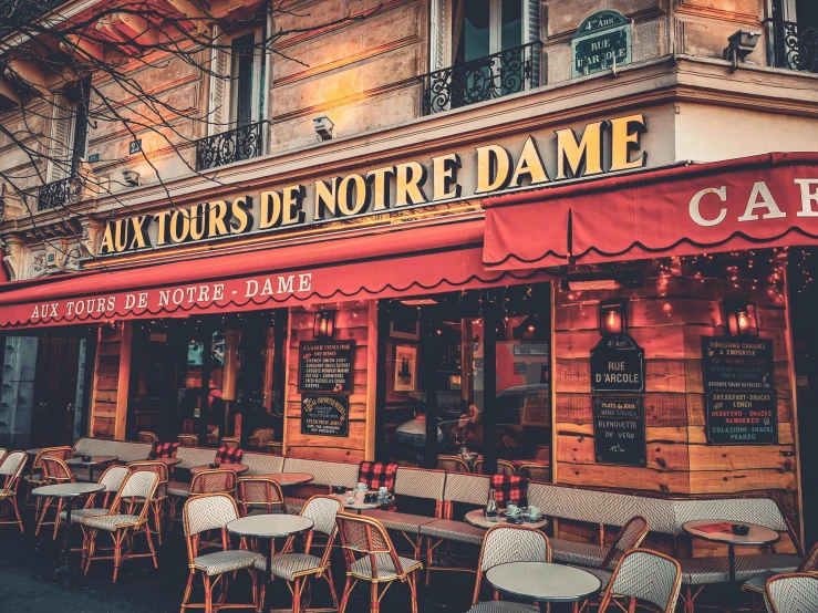 a restaurant with red awnings, tables and chairs