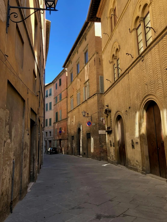 a cobble stone alley with one old house in background