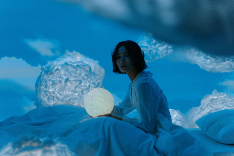 an asian woman sits on the ground next to the sky