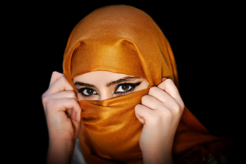 a woman covering her face with a scarf